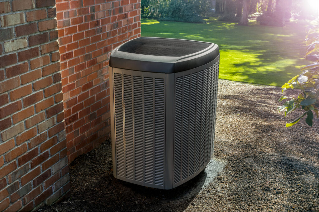 HVAC unit installed next to a brick home.