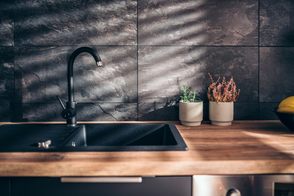 Modern kitchen with black sink and custom wood countertops.