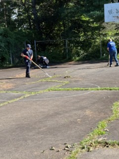 A T.E. Spall & Son team member raking debris at Cerra Park in Carbondale.